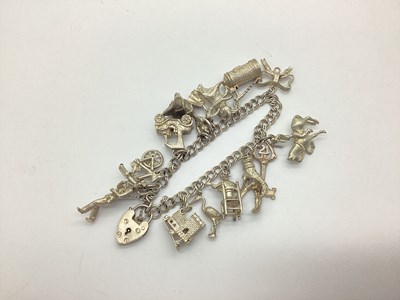 Lot 163 - A Double Curb Link Charm Bracelet, suspending...