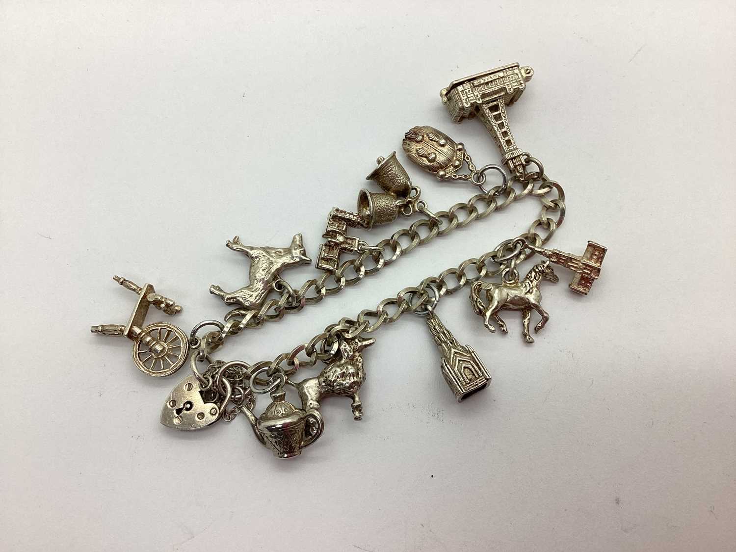 Lot 154 - A Curb Link Charm Bracelet, to heart shape...