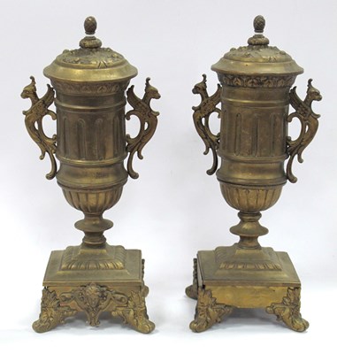 Lot 1396 - A pair of gilded brass vases with finial tops,...