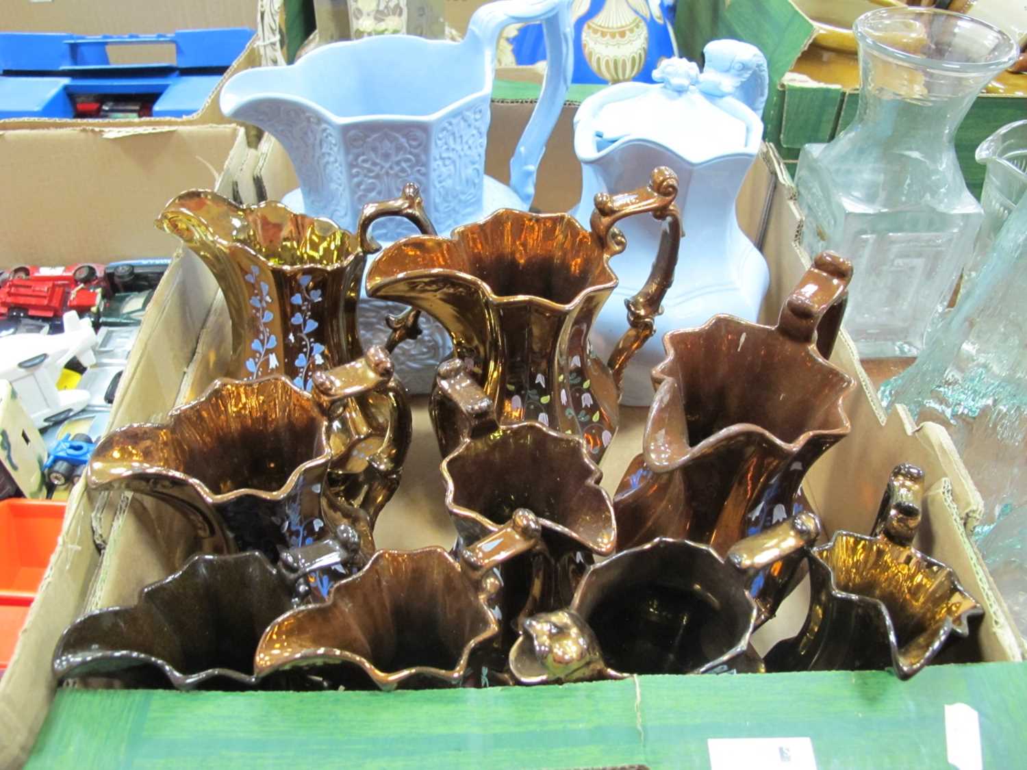 Lot 1114 - Copper Lustre Jugs (x 9), light blue embossed...