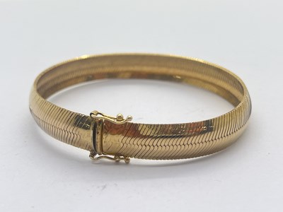 Lot 282 - A Flat Herringbone Link Bracelet, stamped "375"...