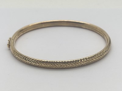 Lot 108 - A 9ct Gold Flexi Bangle, hollow, of textured...