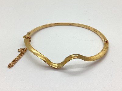 Lot 73 - A 14ct Gold Hinged Bangle, of plain wavy...