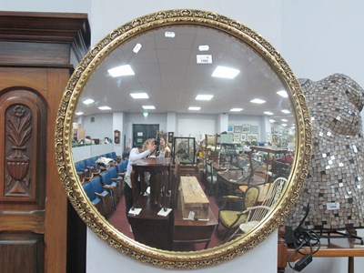 Lot 1468 - A convex circular wall mirror with gilt frame,...