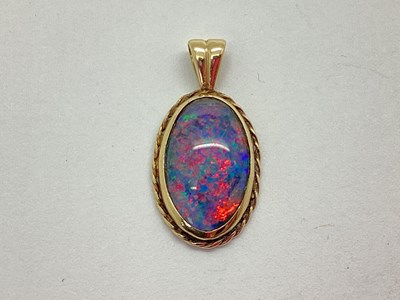 Lot 69 - A 9ct Gold Opal Doublet (?) Pendant, the oval...