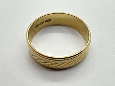 Lot 112 - A Textured Wedding Band Ring, torpedo style...