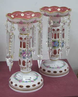 Lot 1140 - A pair of pink glass lustres hand painted with...