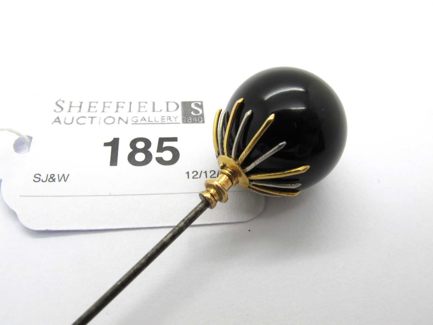 Lot 185 - A Decorative Two-Tone Topped Hatpin, the...