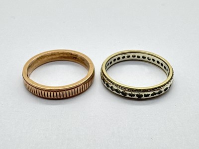 Lot 70 - A Two-Tone Stone Set Eternity Band, (one stone...