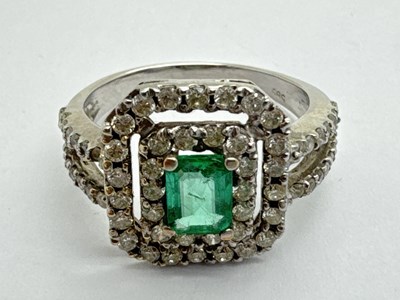 Lot 225 - An Emerald and Diamond Cluster Dress Ring, the...