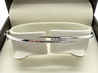 Lot 208 - A Modern Diamond Inset Hinged Crossover Bangle,...
