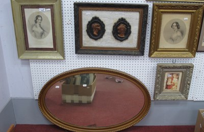 Lot 1534 - A large oval wall mirror with bevelled edge...