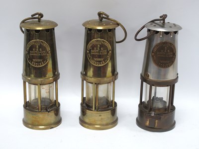Lot 1455 - Three Brass Miners Lamps by Projector Lamp and...