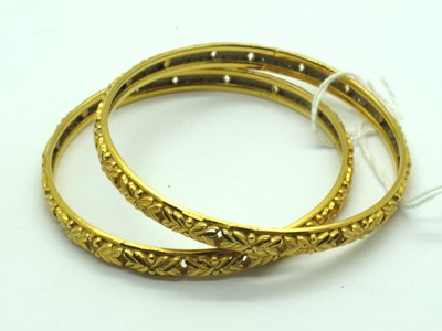 Lot 137 - A Pair of Indian Bangles, allover textured and...