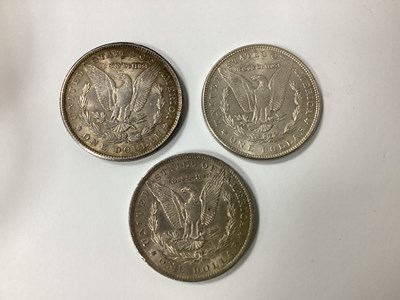Lot 580 - Three USA Silver 'Morgan' Dollars, 1884, 1886,...