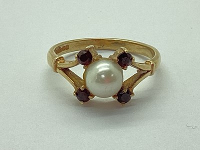 Lot 66 - A 9ct Gold Pearl and Garnet Ring, between...