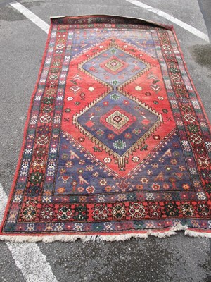 Lot 1604 - Middle Eastern Wool Rug, with a central red...