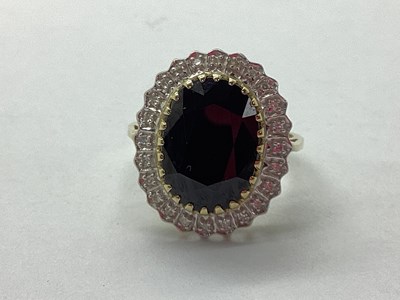 Lot 74 - A Large Oval Sapphire and Diamond Cluster Ring,...