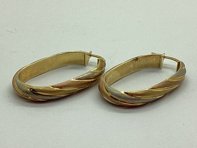 Lot 90 - A Pair of Oval Tri-Colour Hollow Hoop Earrings,...