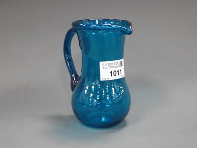 Lot 1011 - A Turquoise Glass Jug, the speckled body with...