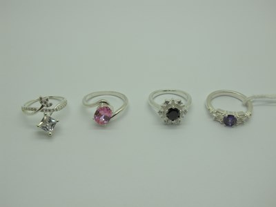 Lot 548 - Four Modern Dress Rings, claw set, stamped...