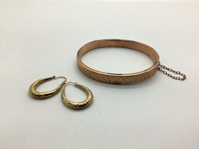 Lot 206 - A 9ct Gold Hinged Bangle, leaf engraved to the...